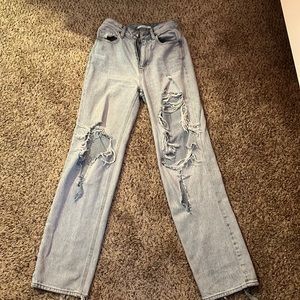 blue, mom-style jeans with large rips at the front